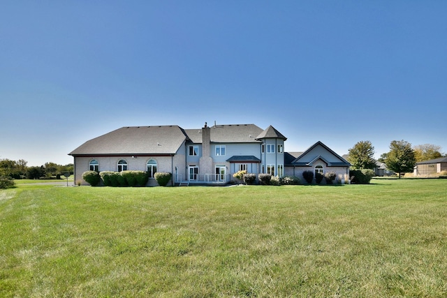 rear view of property featuring a lawn