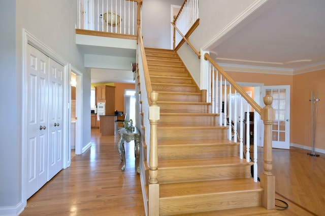 staircase featuring crown molding and hardwood / wood-style floors