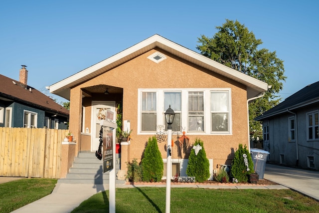 bungalow-style house featuring a front lawn