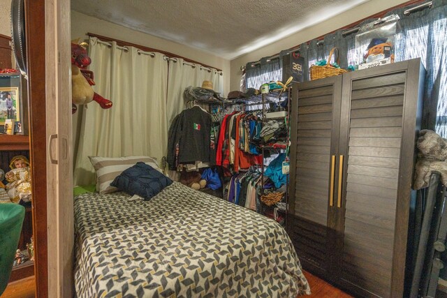 bedroom featuring hardwood / wood-style floors and a textured ceiling