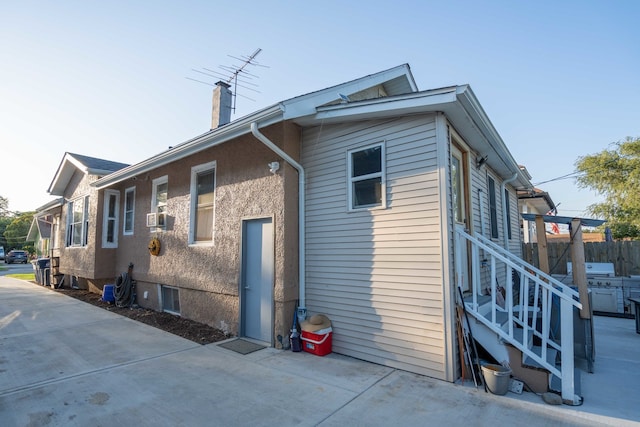 view of side of property featuring cooling unit and a patio area