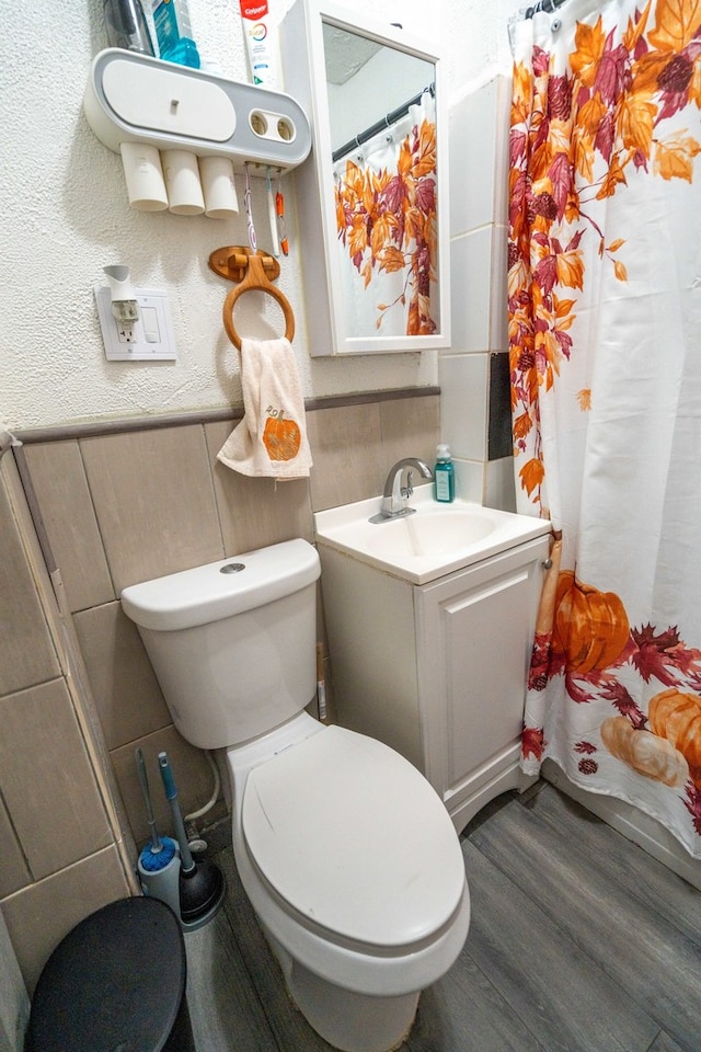 bathroom with toilet, vanity, wood-type flooring, and a shower with curtain