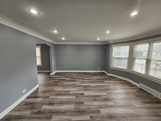 spare room featuring ornamental molding and dark wood-type flooring