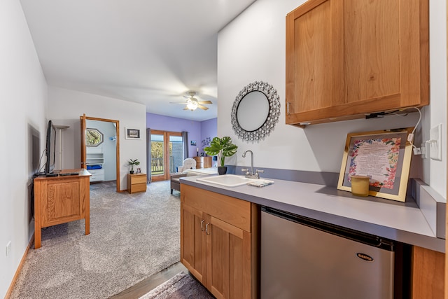 kitchen with light hardwood / wood-style flooring, kitchen peninsula, stainless steel fridge, sink, and ceiling fan