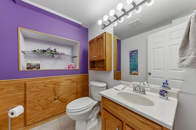 bathroom with toilet, vanity, and tile patterned flooring