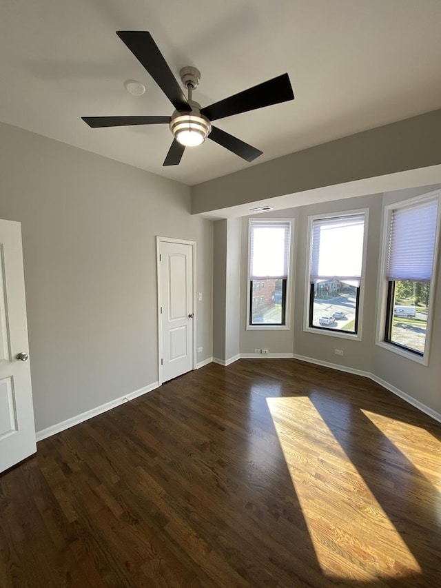 unfurnished bedroom featuring ceiling fan and dark wood-type flooring