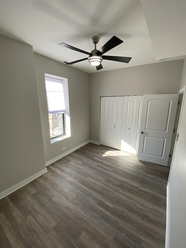 unfurnished bedroom with a closet, ceiling fan, and dark wood-type flooring