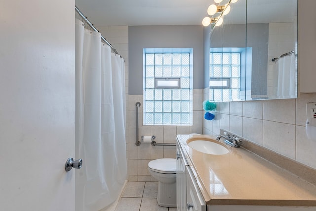 bathroom with vanity, tile walls, tile patterned flooring, and toilet