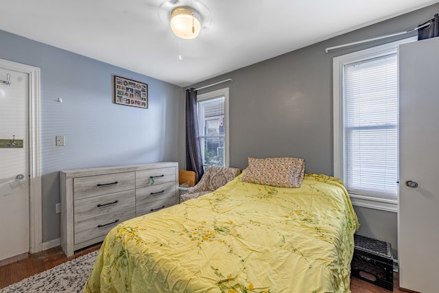 bedroom with dark wood-type flooring and multiple windows