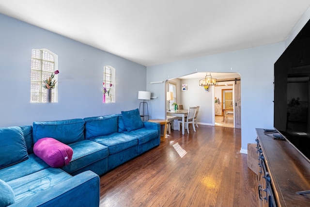 living room featuring dark wood-type flooring and a chandelier