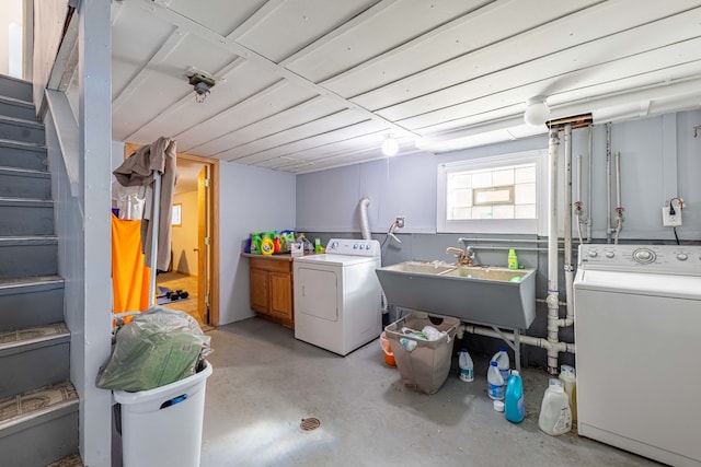 washroom with cabinets, sink, and washer and clothes dryer