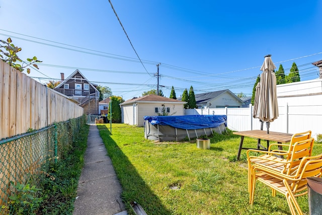 view of yard with a storage unit and a covered pool