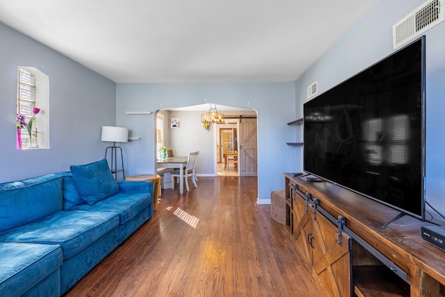 living room featuring a barn door and dark hardwood / wood-style flooring