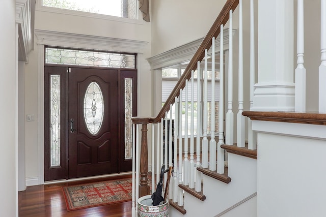 entryway with a towering ceiling and dark hardwood / wood-style floors