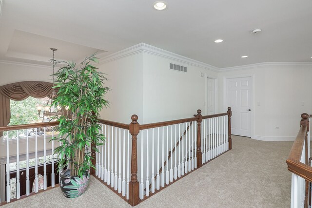 hall with ornamental molding and light carpet