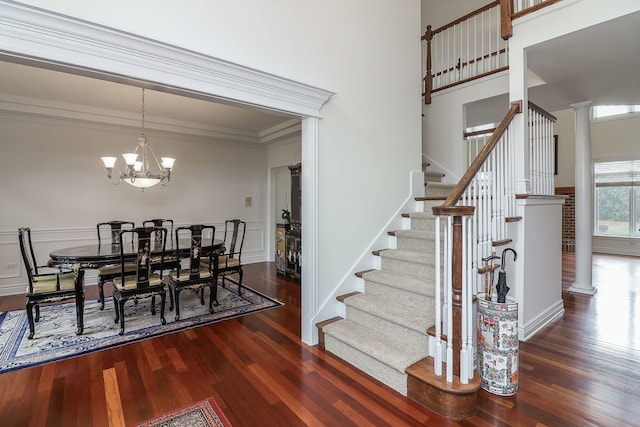 dining room featuring ornate columns, a notable chandelier, crown molding, and dark hardwood / wood-style flooring