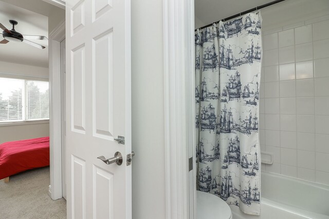 bathroom featuring ceiling fan, toilet, and shower / bath combo