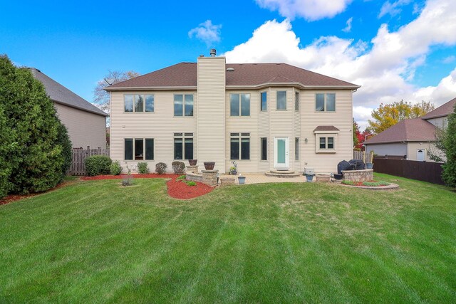 rear view of house featuring a yard and a patio