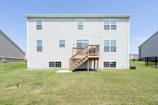 rear view of property featuring a wooden deck, a lawn, and central AC unit