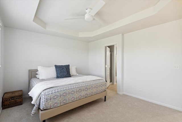 bedroom featuring light carpet, a raised ceiling, and ceiling fan