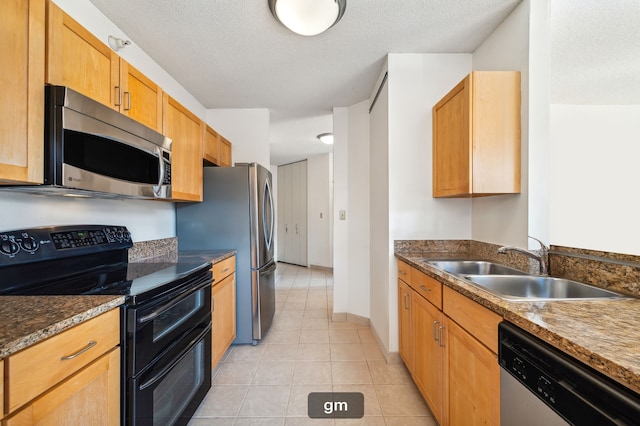 kitchen featuring light tile patterned flooring, sink, stainless steel appliances, and a textured ceiling