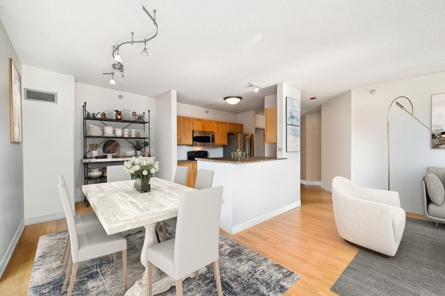 dining space featuring light wood-type flooring