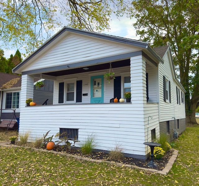 bungalow with a front lawn and covered porch