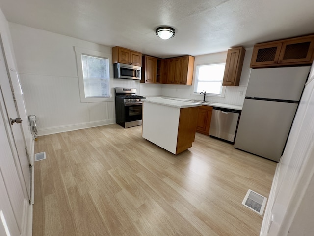 kitchen with visible vents, a sink, light countertops, appliances with stainless steel finishes, and light wood-style flooring