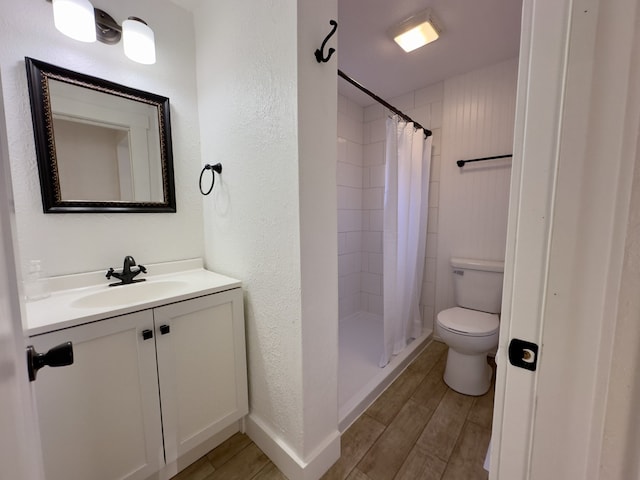 bathroom with wood-type flooring, a shower with curtain, vanity, and toilet