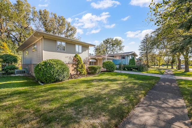 view of front of house with a front lawn and central AC unit