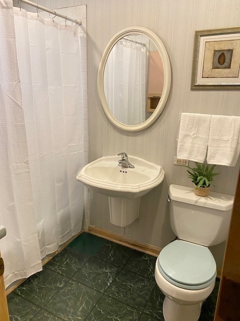 bathroom featuring curtained shower and toilet