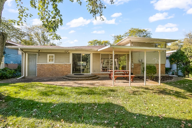 rear view of property with a lawn and a patio area