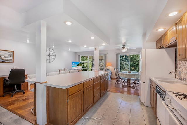 kitchen featuring ceiling fan, light wood-type flooring, sink, and white appliances