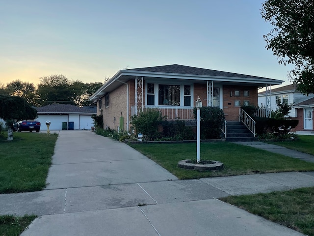 bungalow-style house with a garage, a lawn, and covered porch