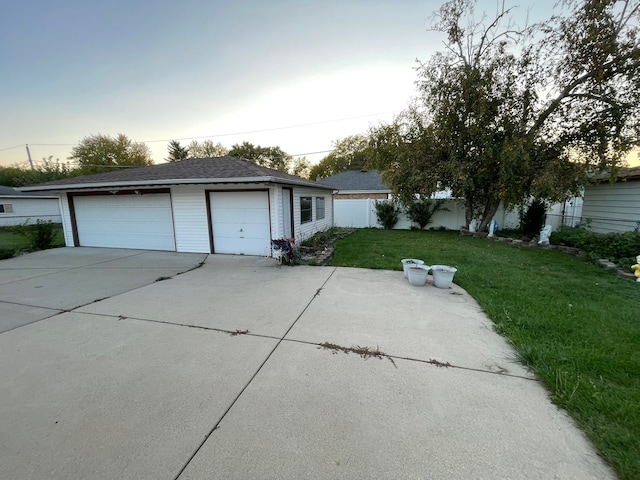 ranch-style home featuring a garage and a lawn