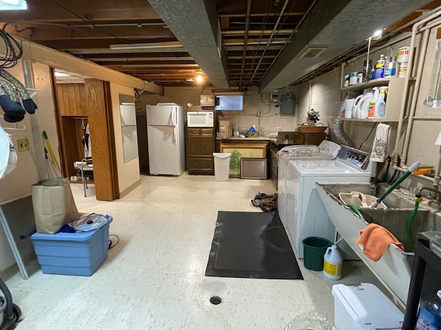 basement with white fridge, independent washer and dryer, and electric panel