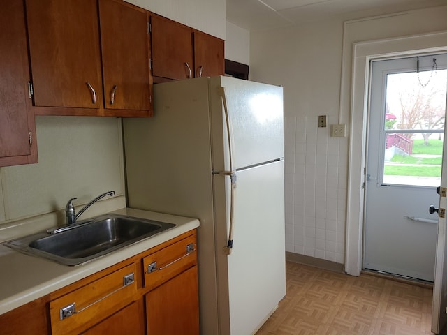 kitchen featuring white fridge, light parquet floors, and sink