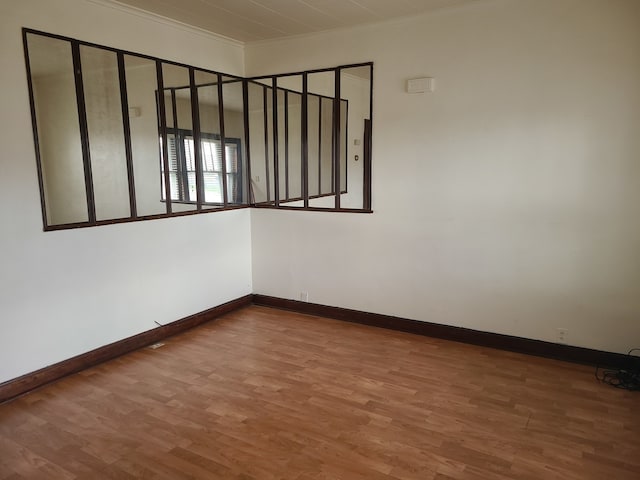 empty room with hardwood / wood-style floors and ornamental molding