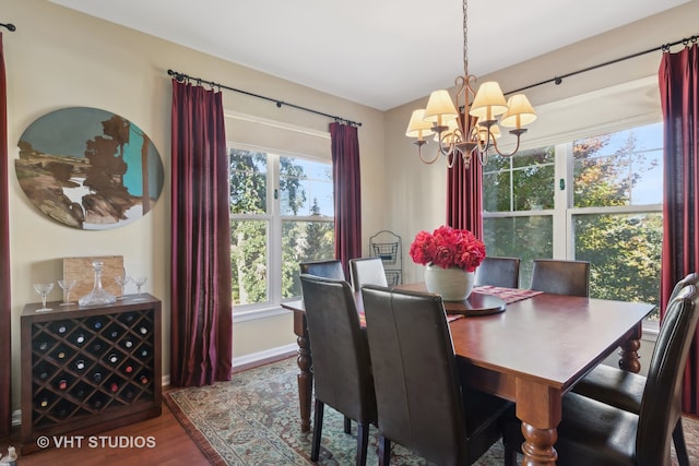 dining area featuring a wealth of natural light, hardwood / wood-style flooring, and an inviting chandelier