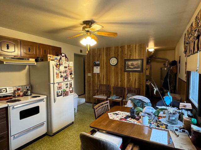 kitchen with white appliances, ceiling fan, wooden walls, and dark brown cabinets