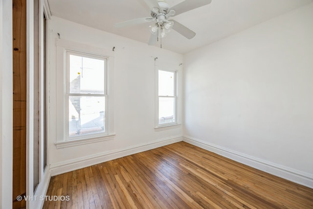 unfurnished room featuring ceiling fan, a wealth of natural light, and wood-type flooring