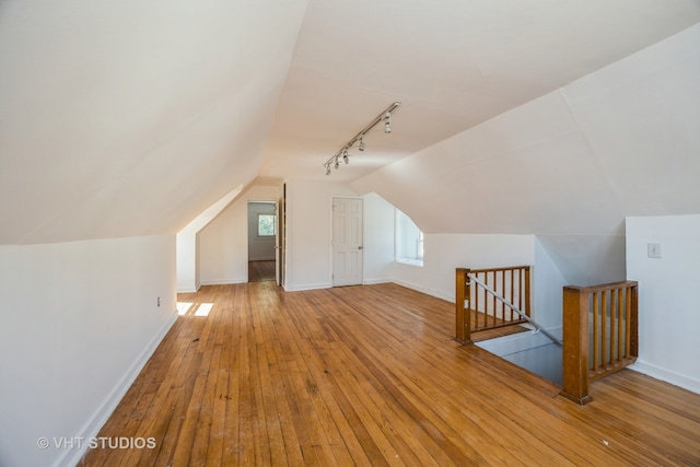 bonus room with wood-type flooring and vaulted ceiling