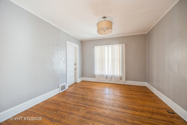 empty room featuring ornamental molding and hardwood / wood-style floors