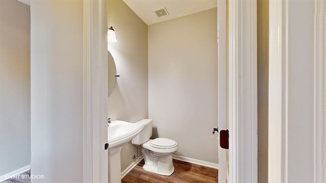 bathroom with toilet and wood-type flooring