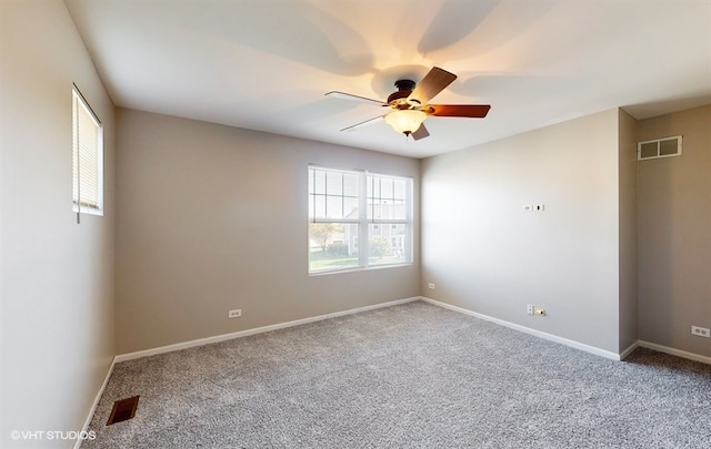 carpeted spare room featuring ceiling fan