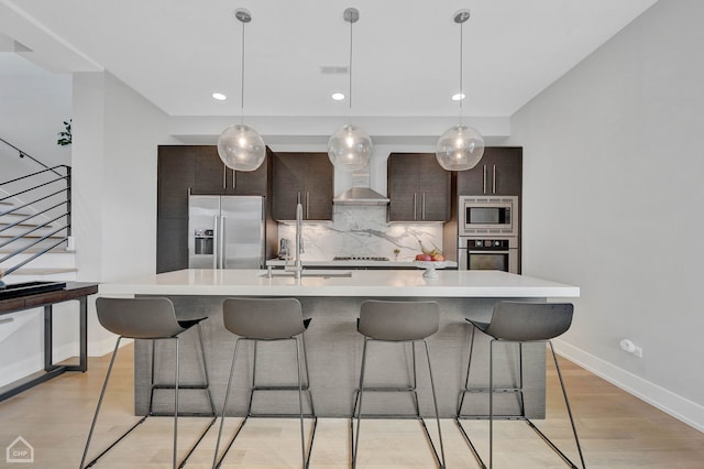 kitchen featuring built in appliances, light countertops, modern cabinets, and dark brown cabinetry