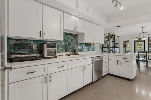 kitchen with dishwasher, kitchen peninsula, light hardwood / wood-style flooring, decorative light fixtures, and white cabinetry