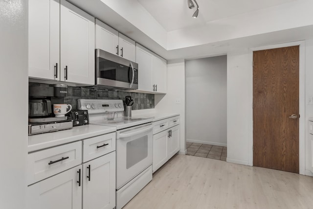 kitchen with track lighting, white cabinets, electric stove, light hardwood / wood-style flooring, and decorative backsplash