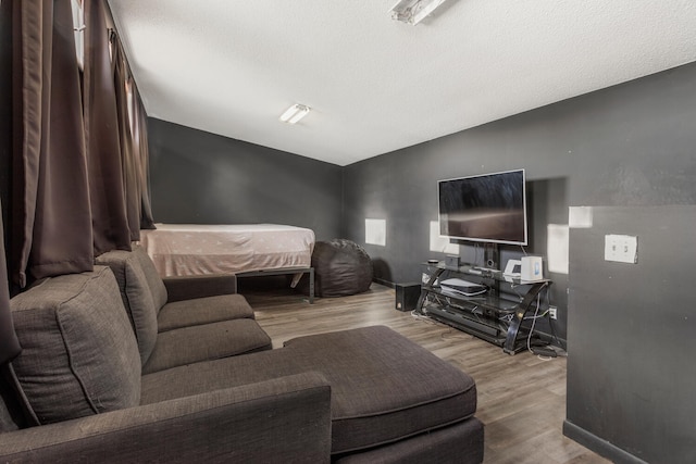 bedroom with a textured ceiling, vaulted ceiling, and light wood-type flooring