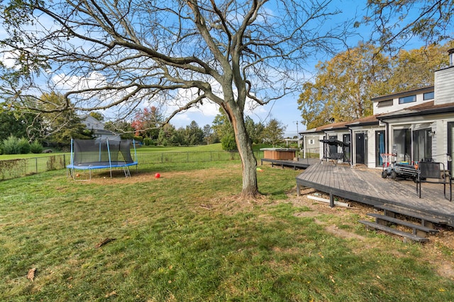 view of yard with a deck and a trampoline